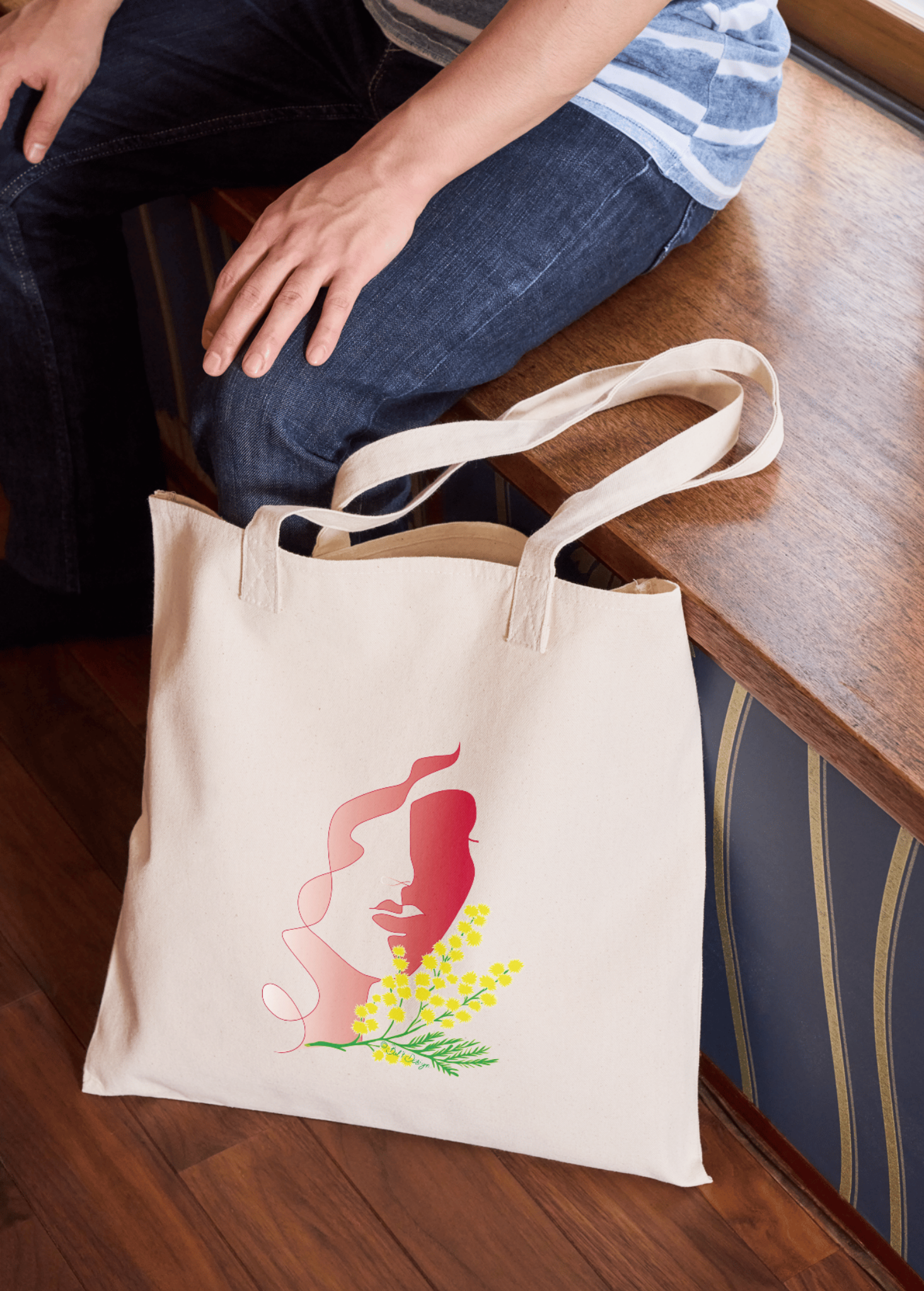 Tote bag en coton naturel illustré d'un visage de femme stylisé en aplat rose avec une branche de mimosa jaune