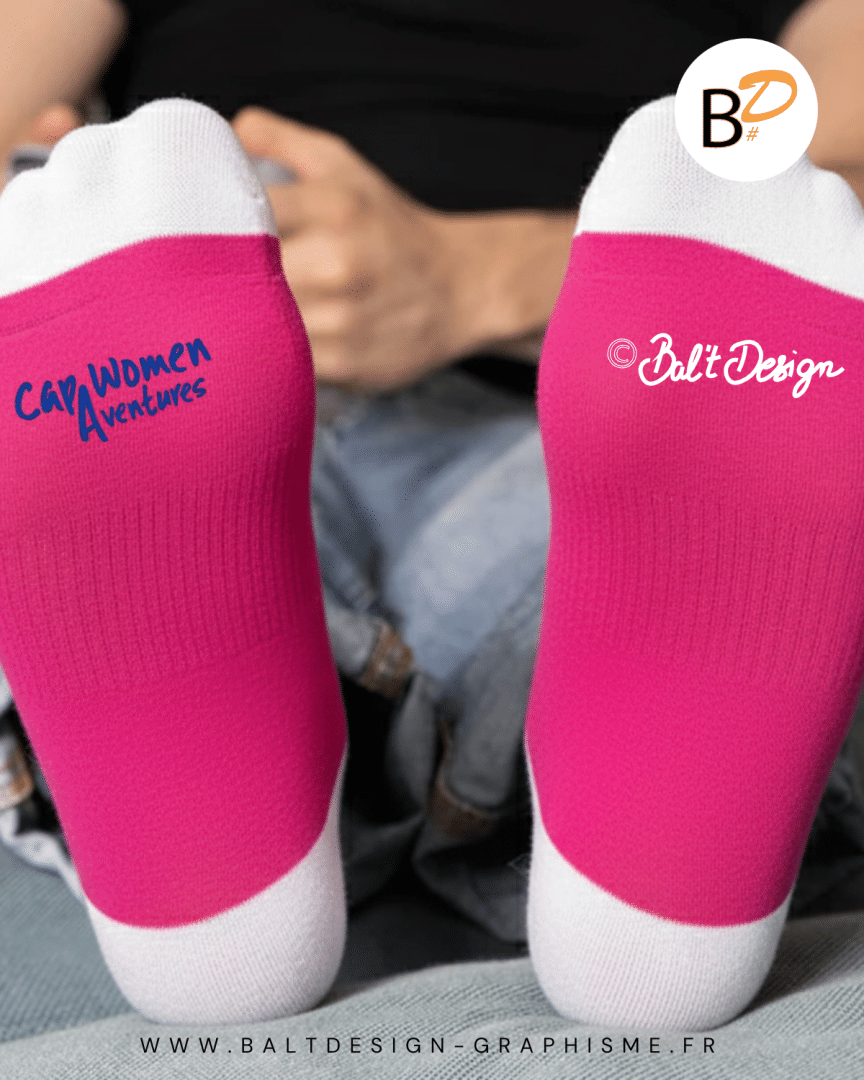 Paire de chaussettes illustrées. Femme courant dans les sentiers de montagnes. Couleurs vives : rose, bleu, jaune.