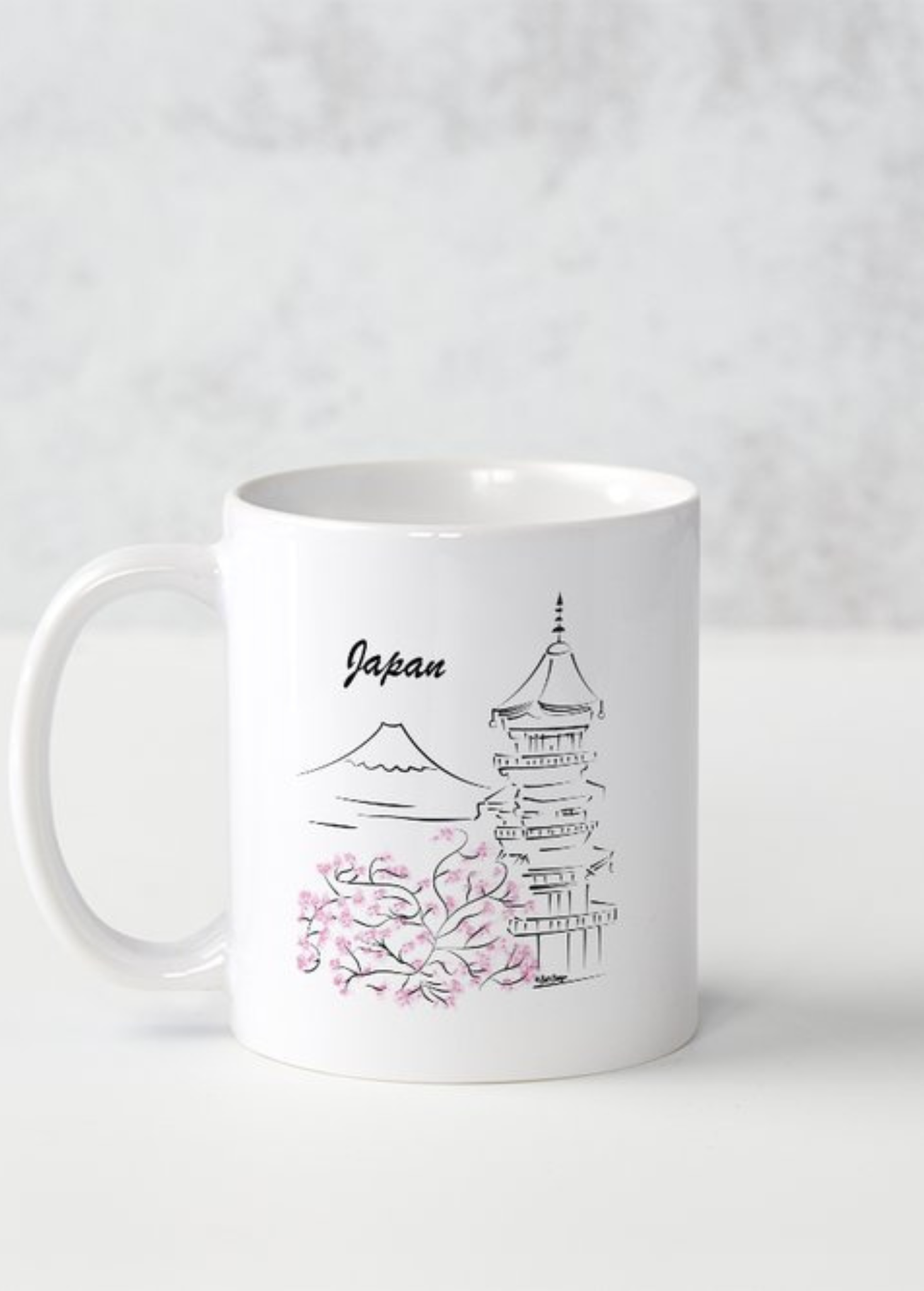 Mug blanc illustré d'un temple japonais au trait fin entouré de branches de cerisiers roses, mot Japan en cursive, style estampe